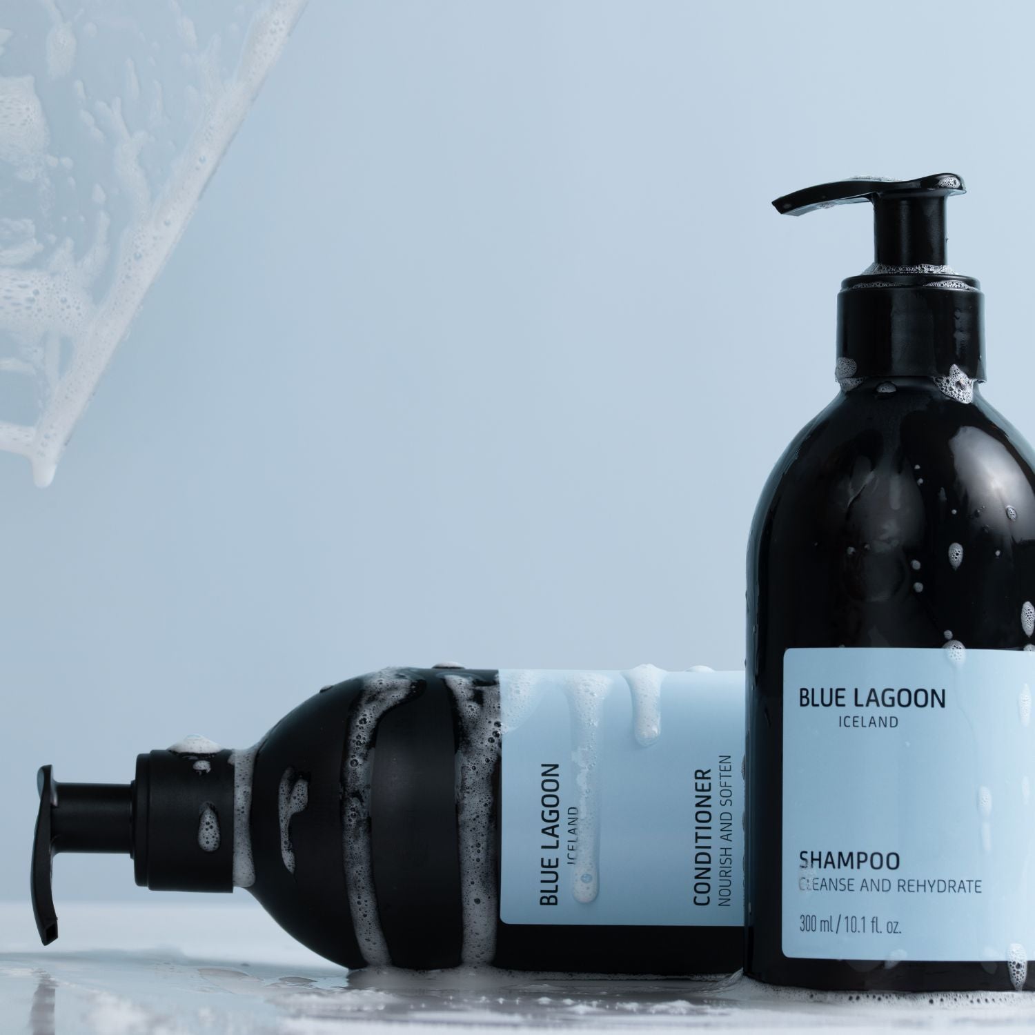 Shampoo flöskur á ljósbláum bakgrunni með myndrænum áherslum á hreinsun, rakagjöf og umhirðu hársvarðar